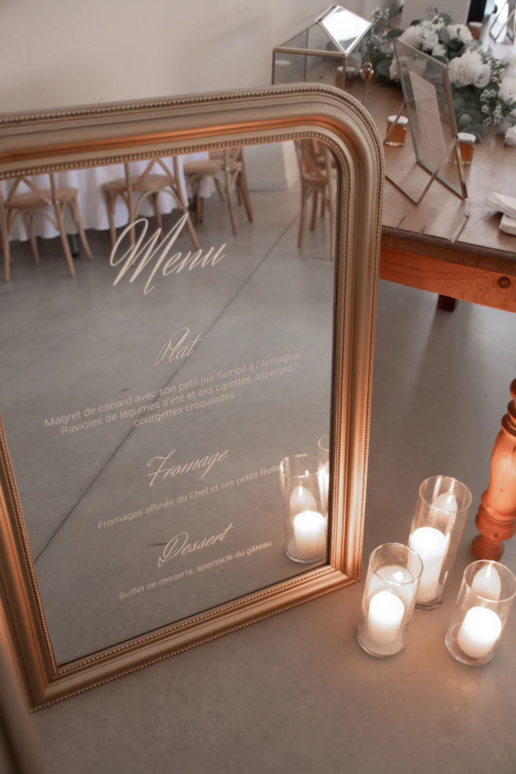 Menu du mariage sur un miroir accompagné de bougies blanches